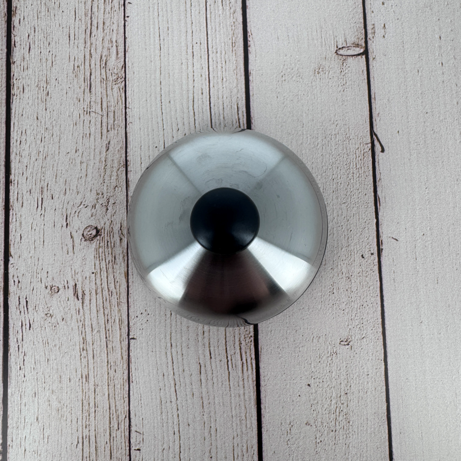 Close-up of the brushed stainless steel lid with matte black knob, a signature detail of the Degrenne Salam collection.