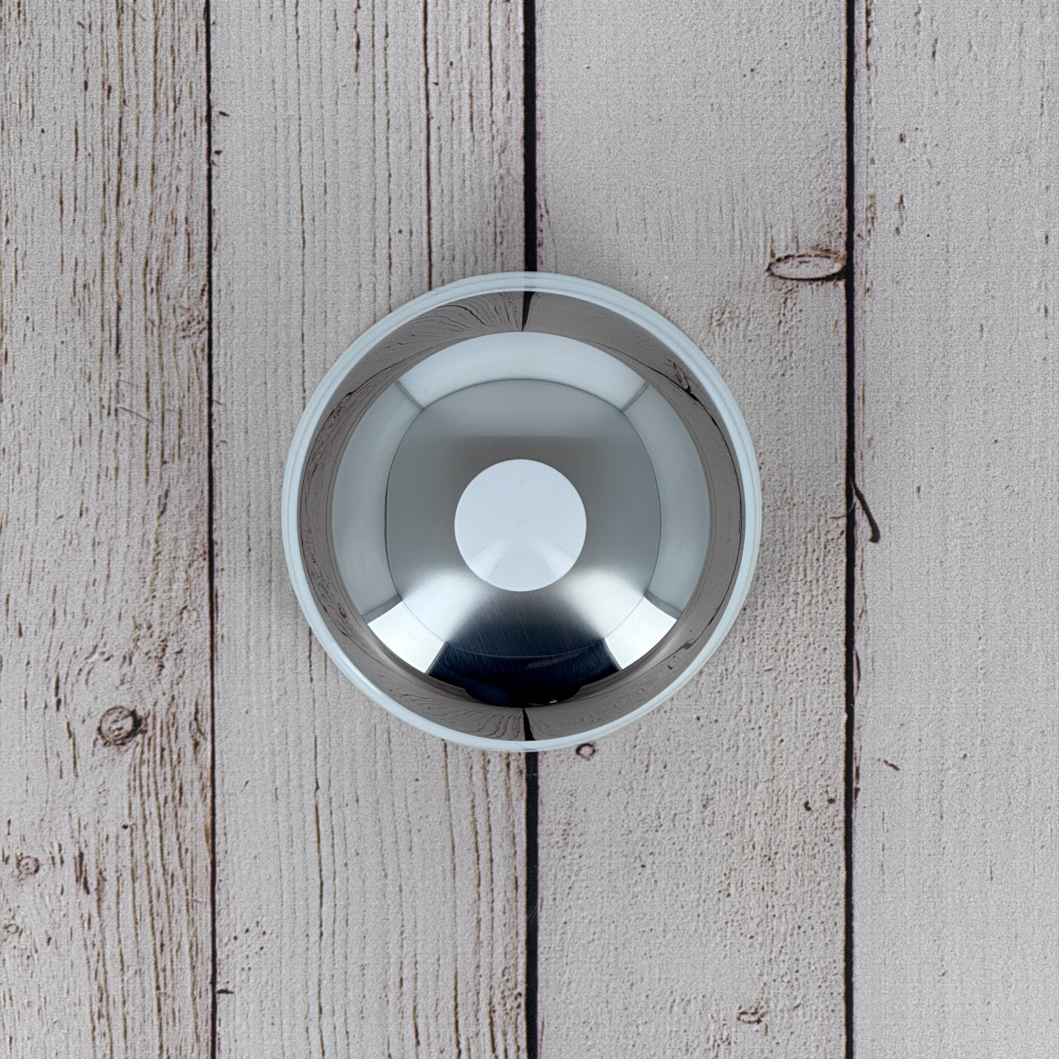 Close-up of the mirror-polished stainless steel lid with white porcelain knob, a signature Degrenne Salam design detail.