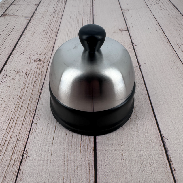 Side view of the domed steel lid and matte black rim, showcasing the refined craftsmanship of Degrenne tableware.